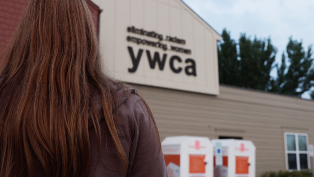 Back of woman's head standing outside YWCA Emergency Shelter